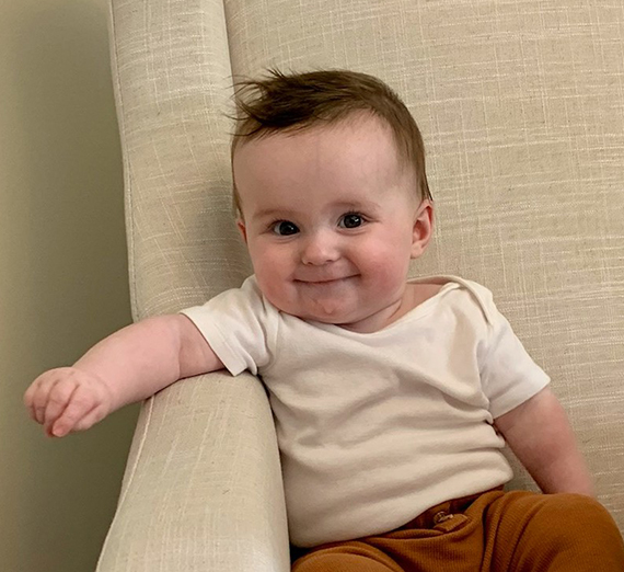 Man and woman holding a dog and a baby